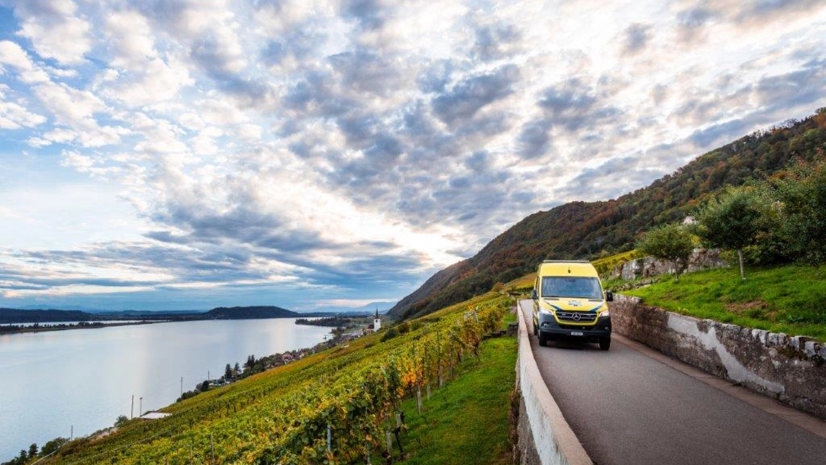 Une ambulance roule sur une route étroite à travers les vignes au bord du lac de Bienne, intervention des services de secours dans une région rurale de Suisse.